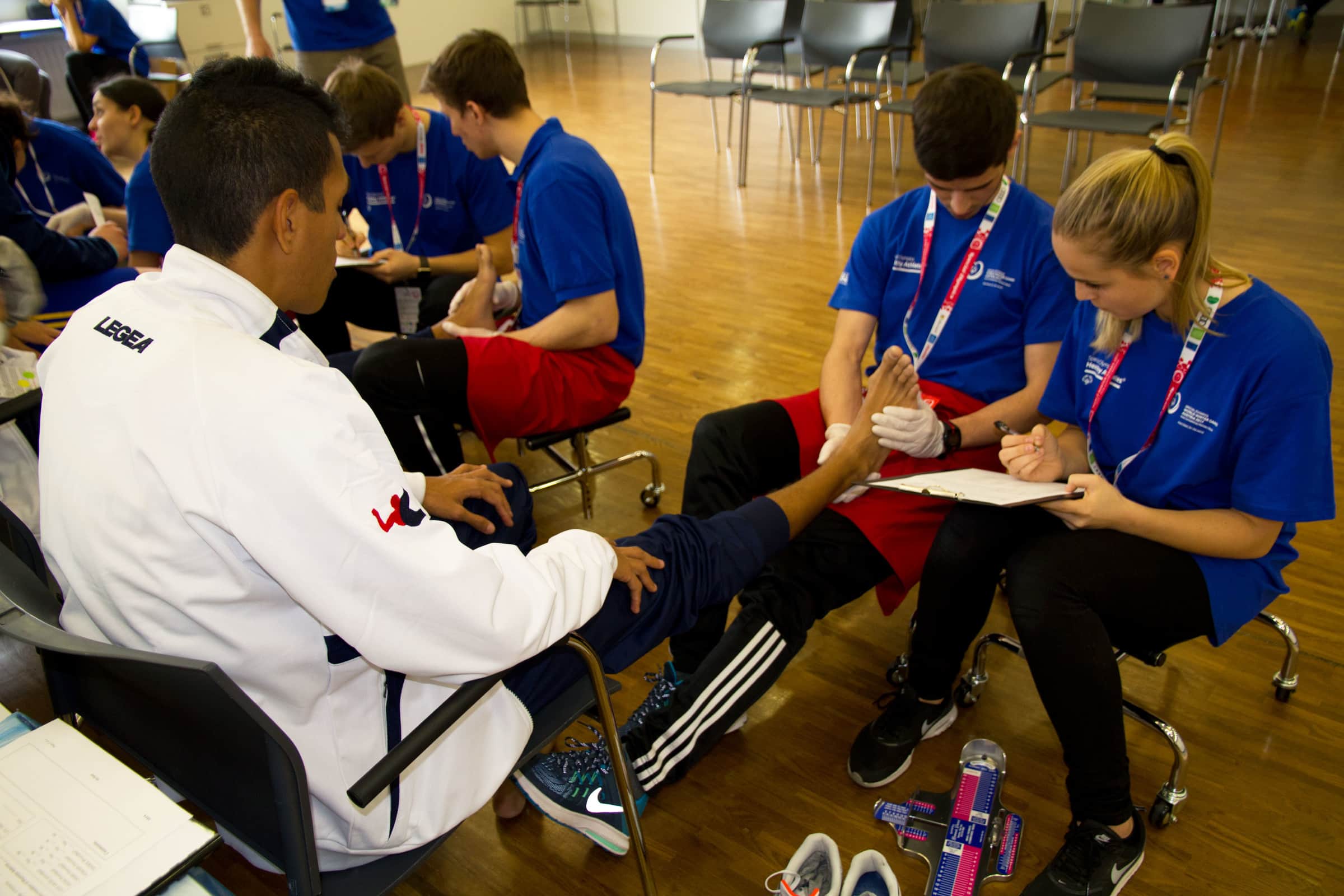 SportlerInnen der Special Olympics werden von Studierenden untersucht.