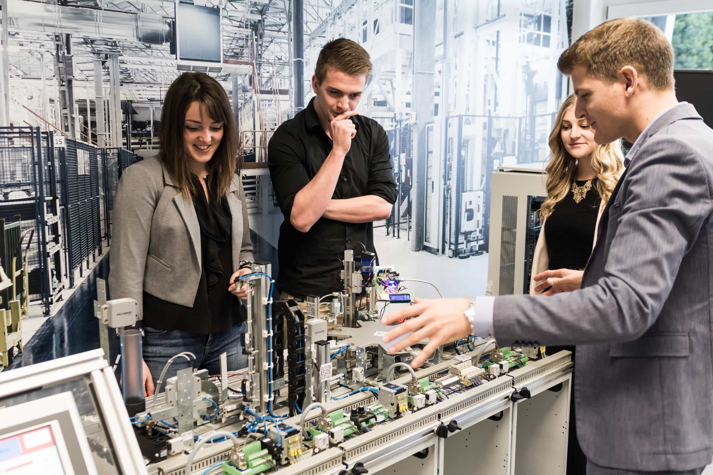 Vier Personen in einem technischen Labor sprechen über die Infrastruktur.