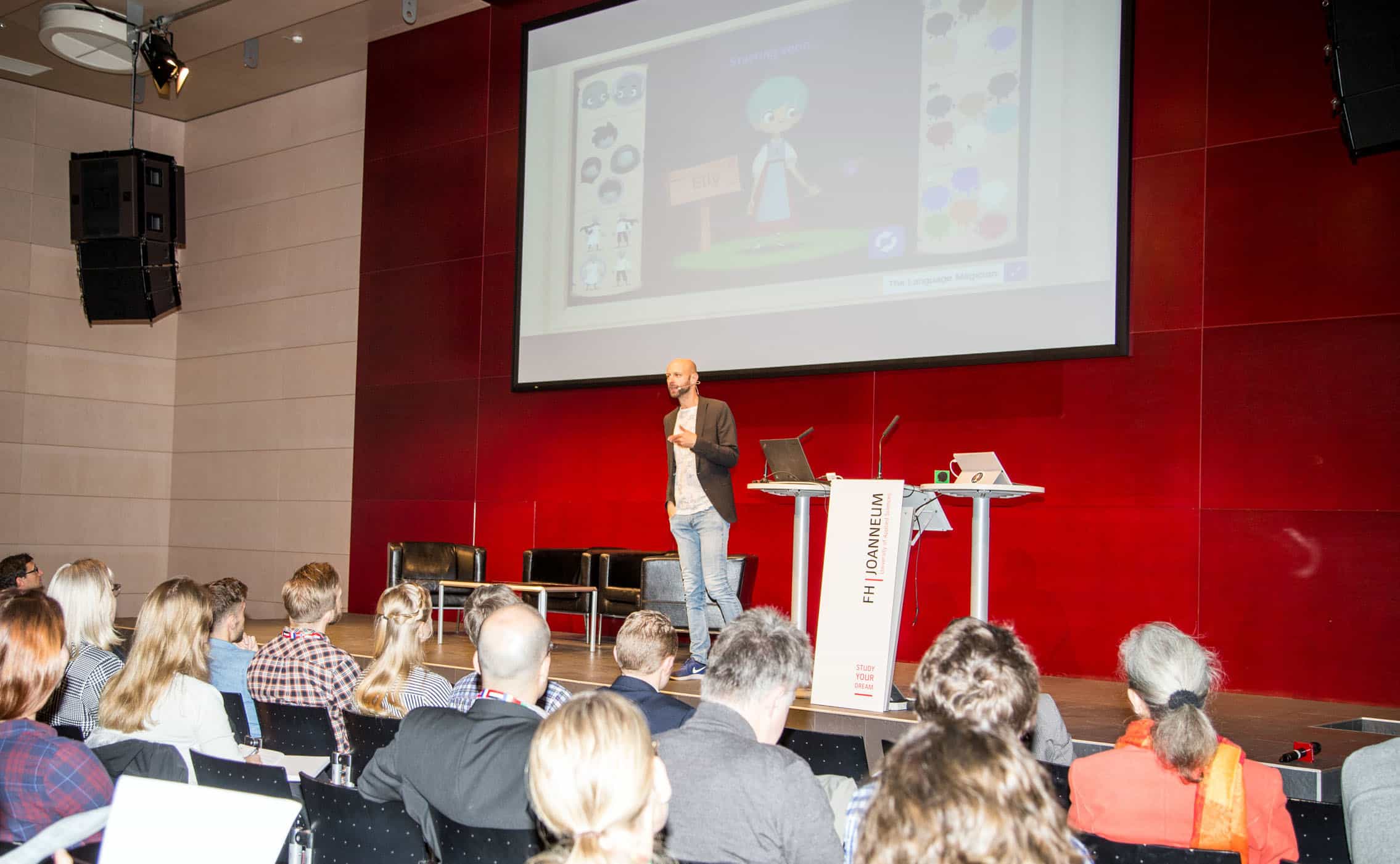 Der Keynote Speaker mit Präsentation im Hintergrund.