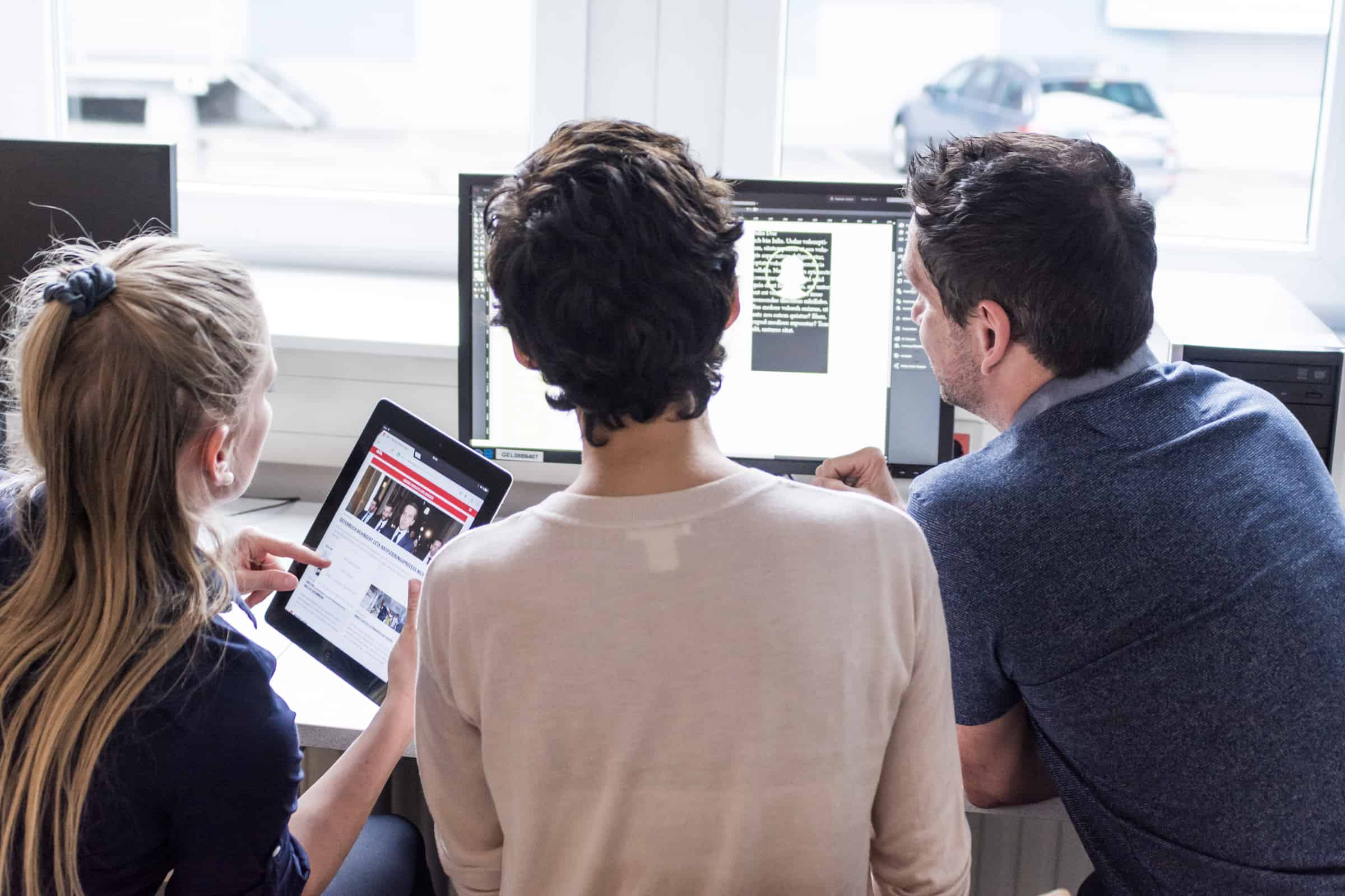 Studierende sehen auf Computerbildschirm.