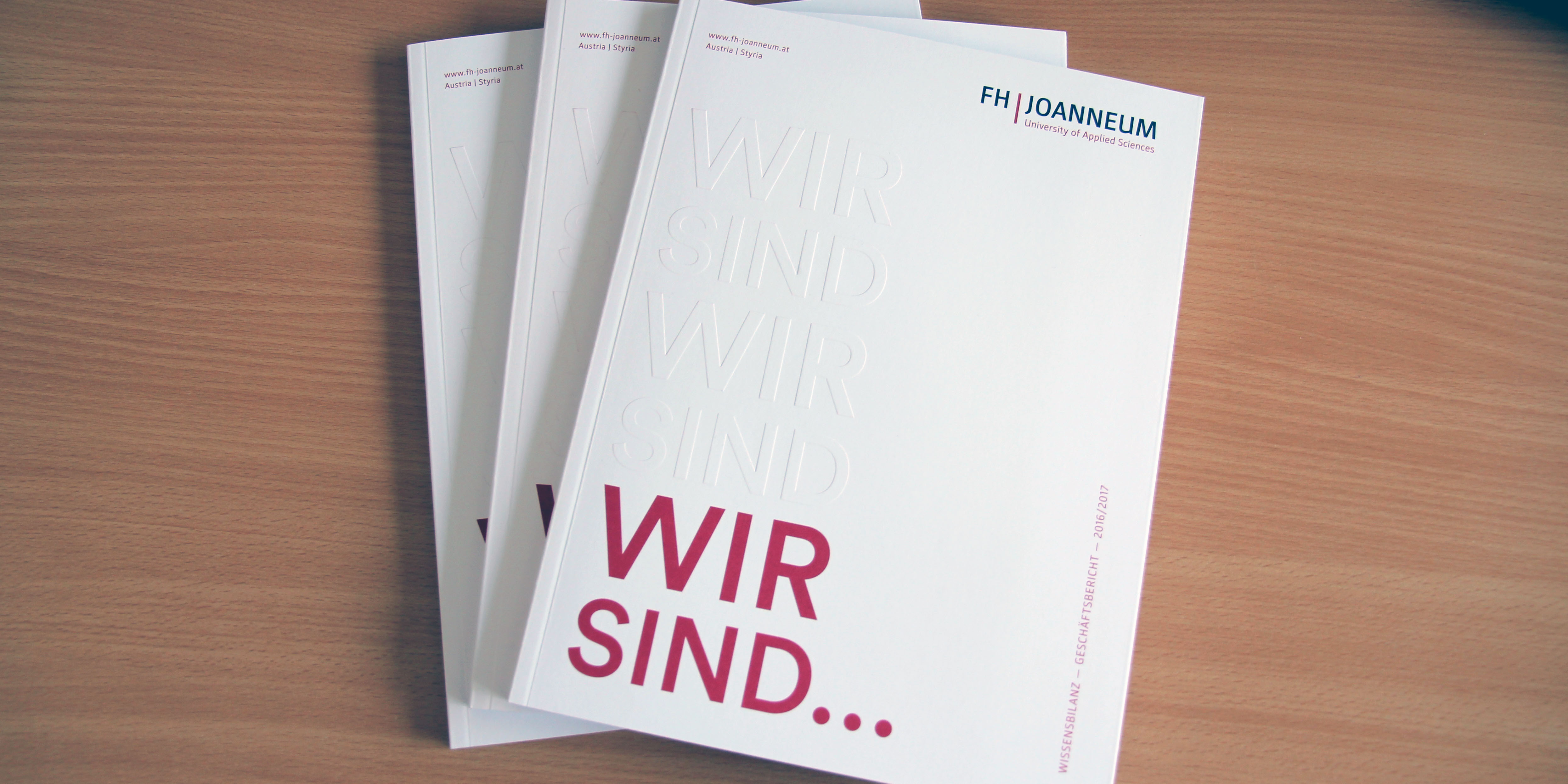 Drei Exemplare des Annual Reports auf einem Tisch.