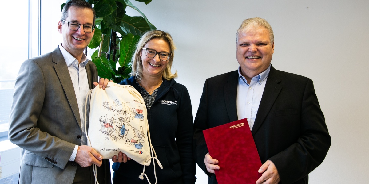 V.l.n.r.: Martin Payer, kaufmännischer Geschäftsführer der FH JOANNEUM, und Birgit Hernády überreichen das Zertifikat an Wolfgang Horvath. Foto: FH JOANNEUM / Wasserfaller Automatisch gespeicherter Entwurf 337