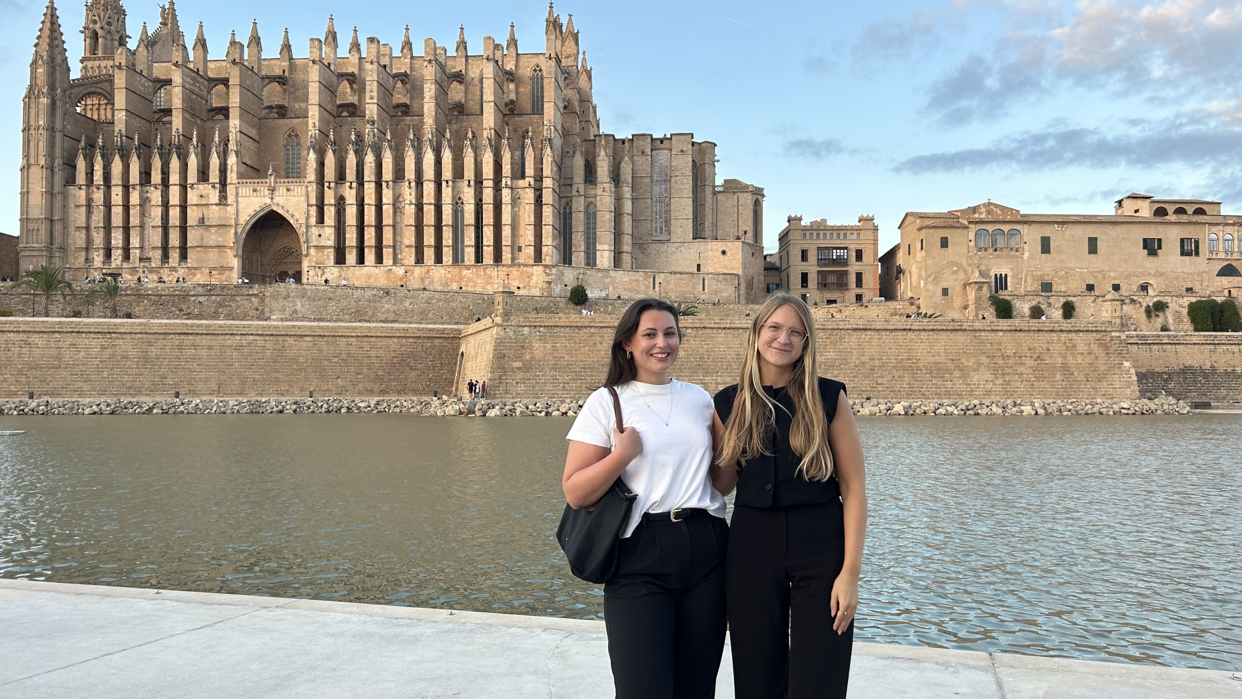 Architektur Absolventinnen Stefanie Wörister und Katharina Santner stehen vor der Kathedrale von Palma und lächeln.