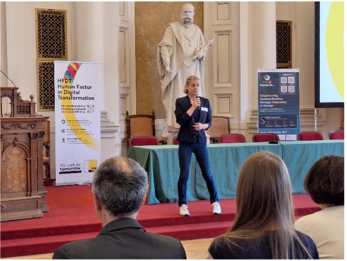 Frau spricht auf Bühne in Uni Graz.